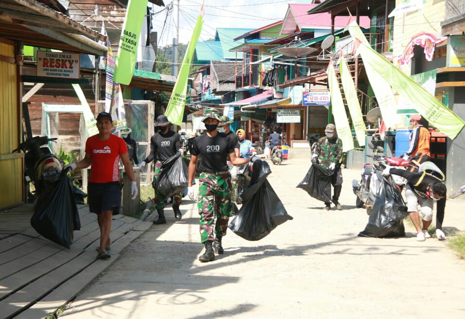 Peduli Kebersihan Satgas Pamtas RI-MLY Yonif Raider 200/BN Ajak Warga Membersihkan Jalanan Kampung