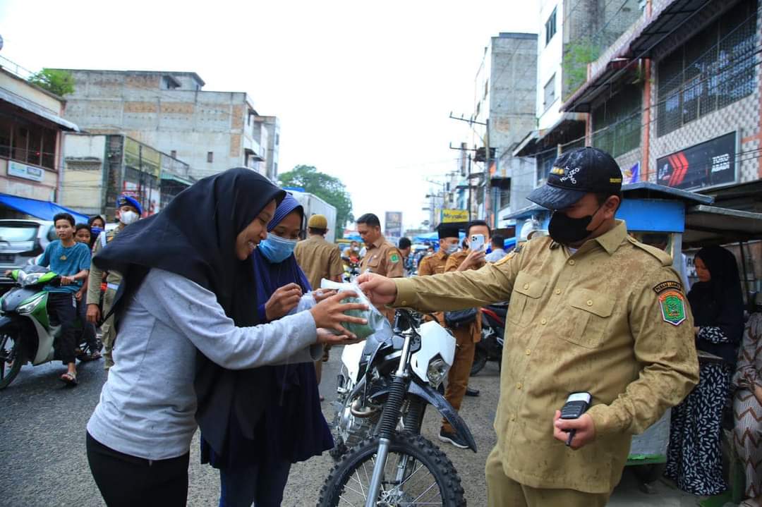 Bupati dan Ketua TP.PKK Labura, membagi-bagi takjil kepada Masyarakat pengguna jasa jalinsum