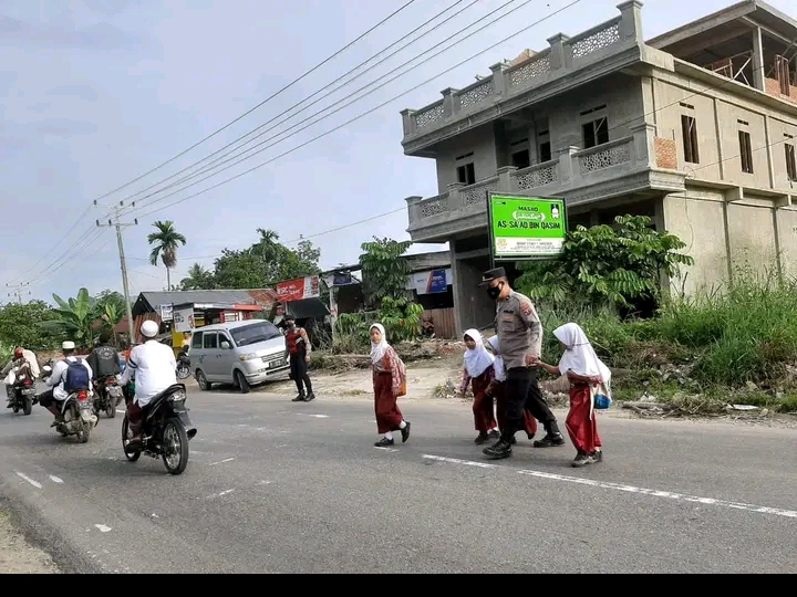 Bantu Anak- anak Menyeberang Jalan, Kini Giliran Kasi Humas Polres Madina Turun Ke Jalan