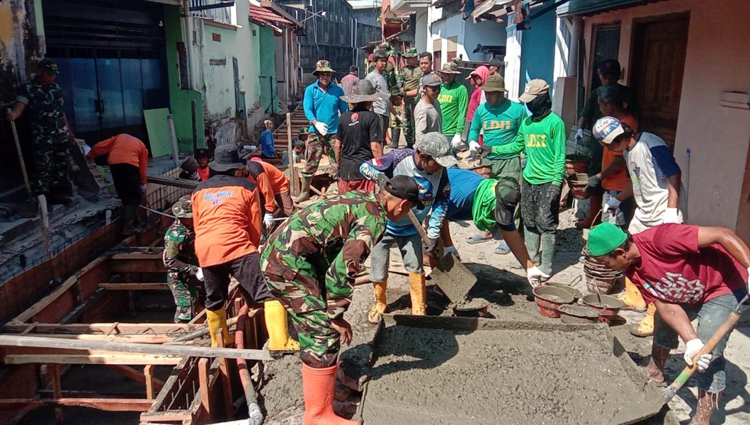 Terik Sinar Matahari Tak Surutkan Satgas TMMD, Ormas dan Warga Dalam Pengecoran Begesteng Kanan Kiri Saluran Air